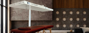 Modern studio apartment with  high intensity canopy style red light therapy device in the corner over a lounge chair.
