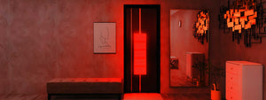 Resort suite with glowing travel red light therapy device on the wall giving the room a warm hue.