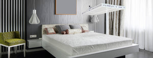 Maximum intensity red light therapy device over a bed in a medieval style room.