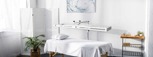 The Beam, full body red light therapy device over a massage table.