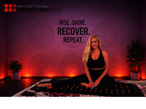 Woman sitting on a PEMF mat with red light therapy.