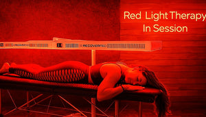 Person receiving whole body red light therapy with text 'Red Light Therapy In Session' on a red background.