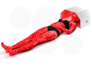 Person lying on the floor using an arch shaped red light therapy device with a white background.