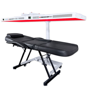 Black massage table with white and red light therapy device on a white background.